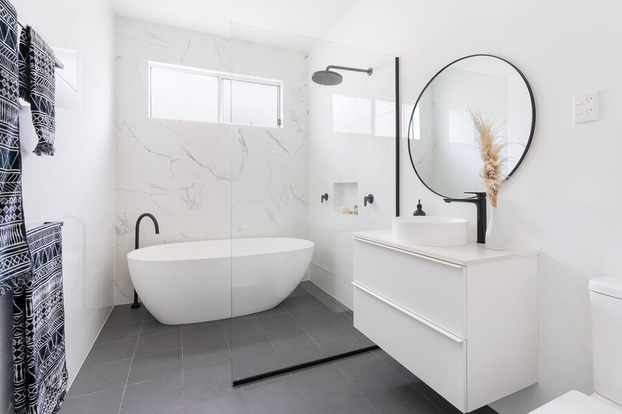 Bathroom with freestanding tub and marble feature wall