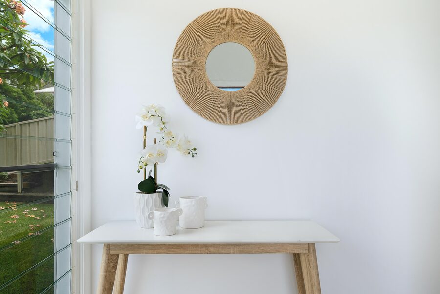 Entry hall with timber console and rattan mirror